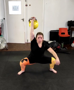 Alexia doing an overhead squat with 16 kg