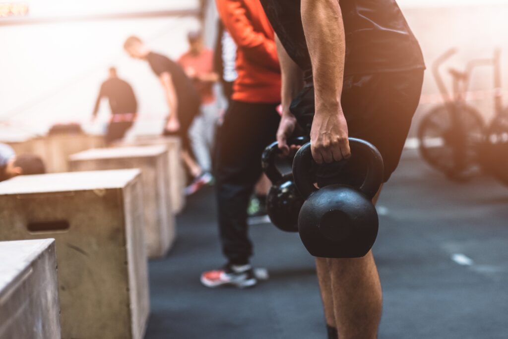 Man pulling kettlebells weights in the functional fitness gym. Kettle bell deadlift