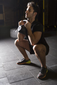 Man doing a squat with a kettlebell