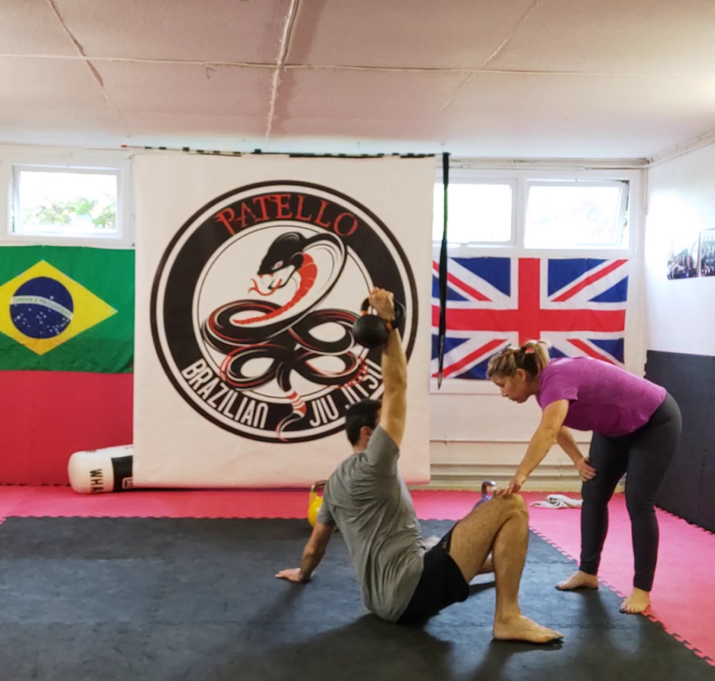 Woman teaching the movement patters of the Turkish get up