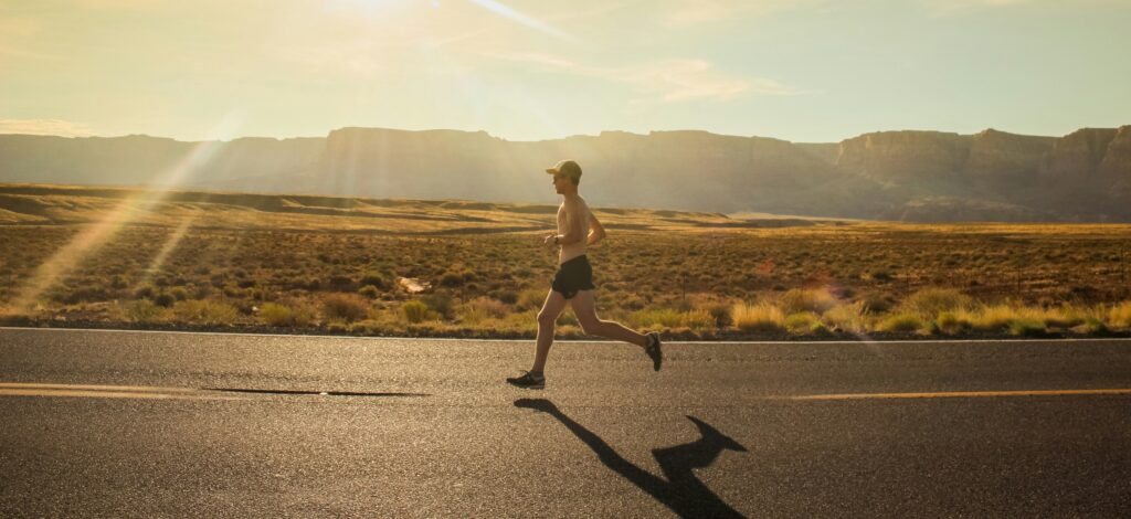 A person running along a road in shorts without t-shirt